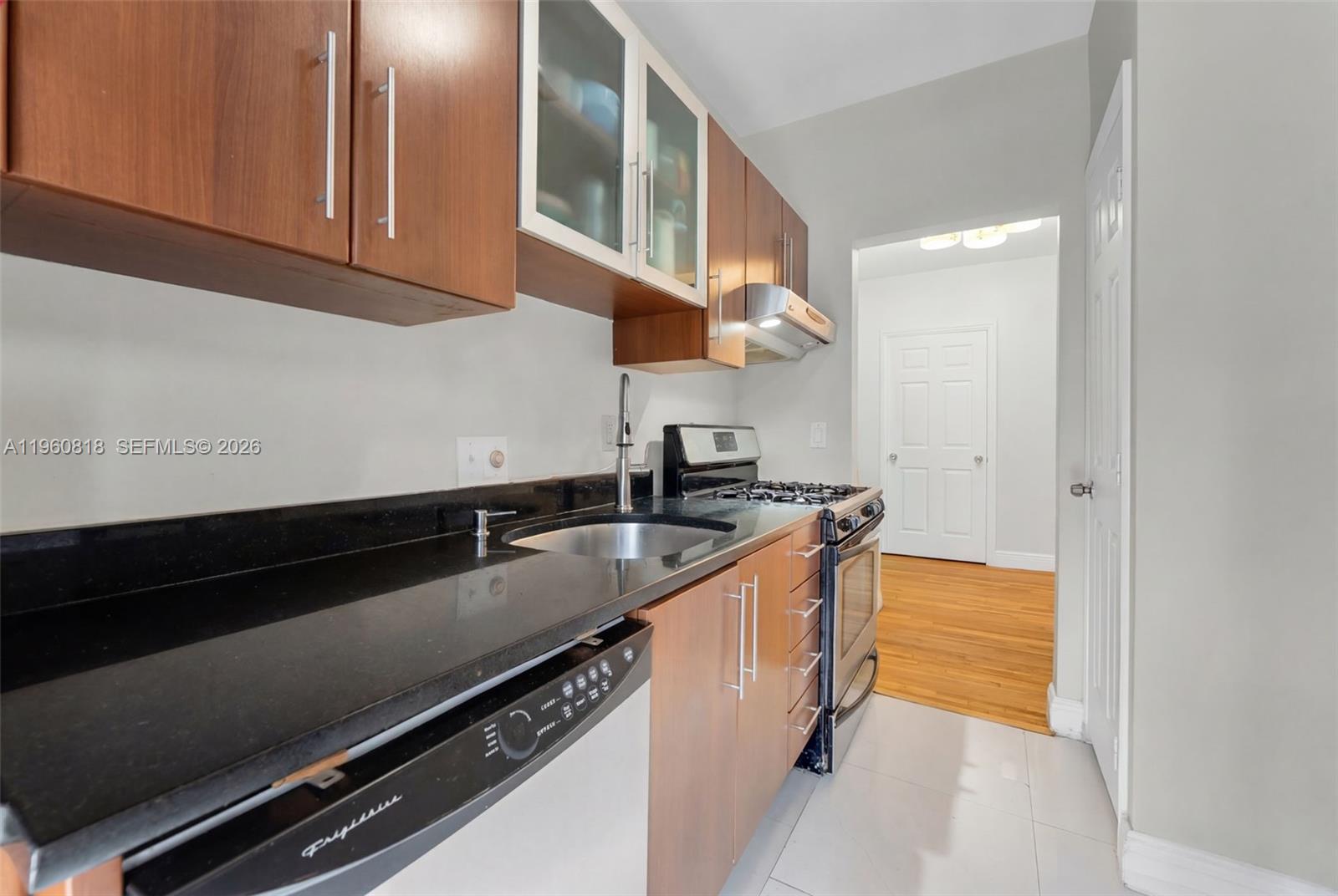 320 85th Street, Unit 15 Miami Beach, FL 33141 - Photo 5 of 13 a kitchen with granite countertop a sink and a stove