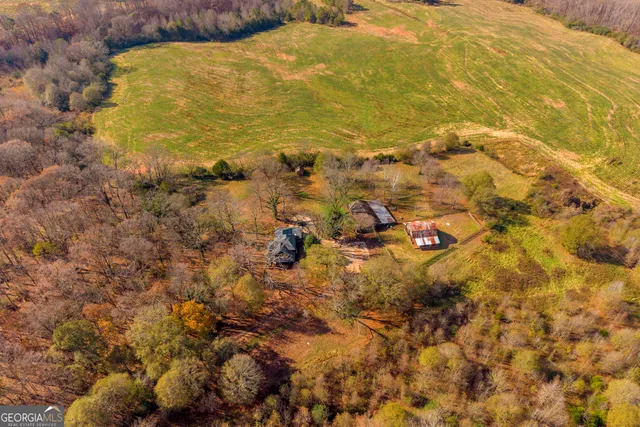 a living room with couches a flat screen tv and a chandelier