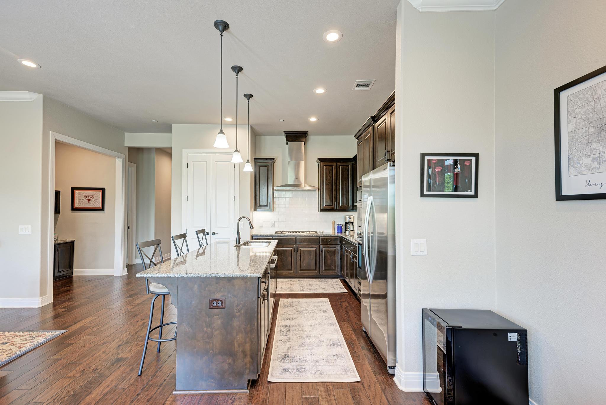 2601 North Quinlan Park Road, Unit 506 Austin, TX 78732 - Photo 15 of 39 An inviting kitchen with rich wood flooring and a modern kitchen island.
