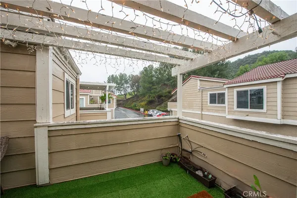 a view of a house and a back yard with a large tree and wooden floor