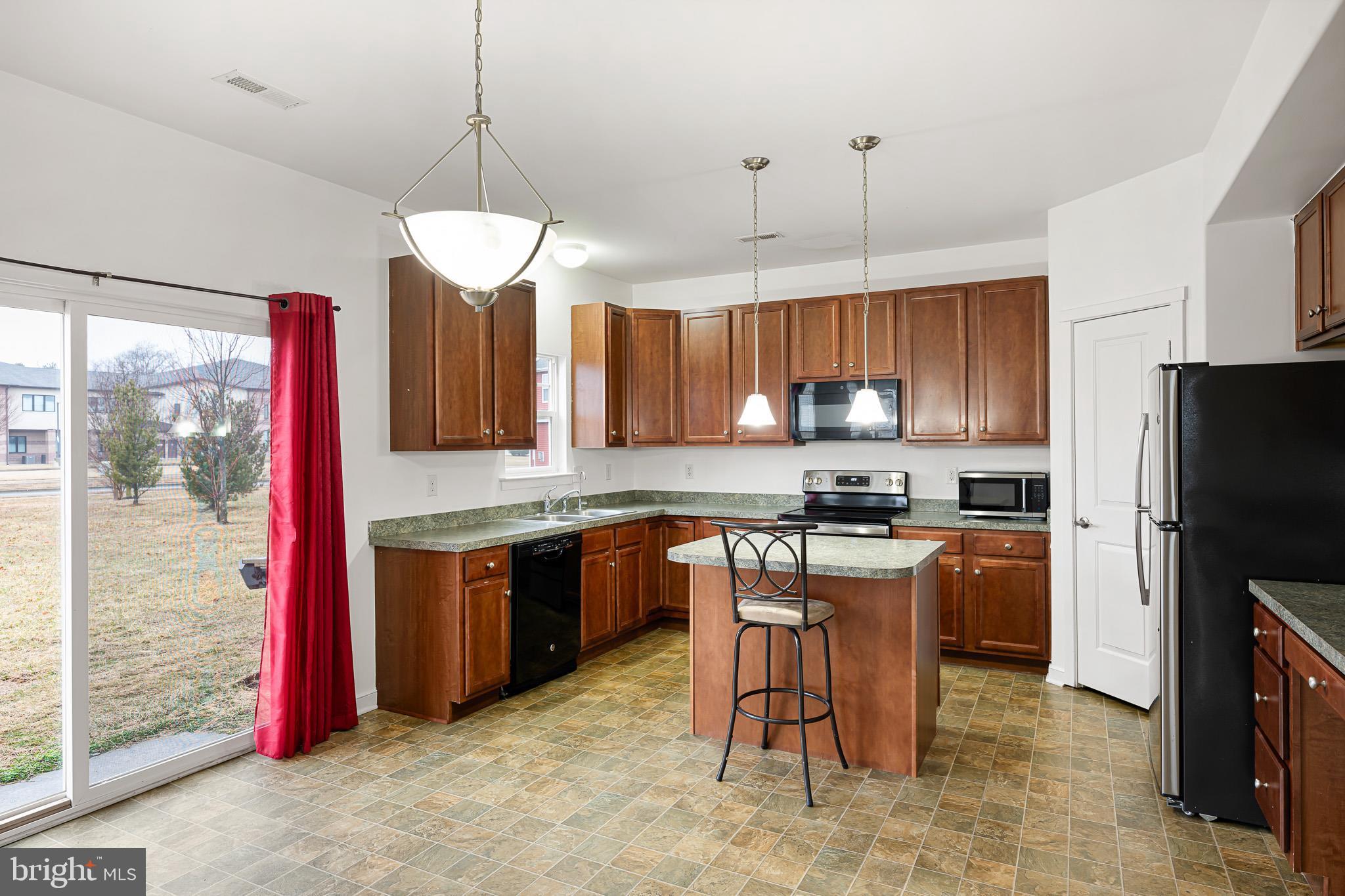 42 Mer Way Dover, DE 19901 - Photo 27 of 36 a kitchen with a refrigerator a sink a stove a dining table and chairs