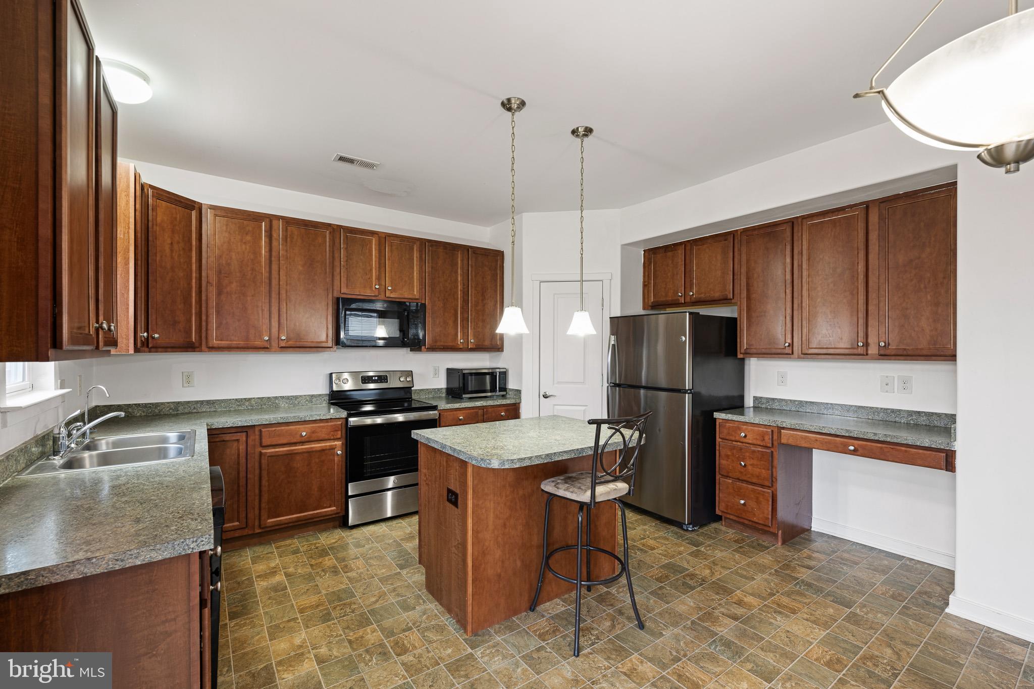 42 Mer Way Dover, DE 19901 - Photo 28 of 36 a kitchen with granite countertop stainless steel appliances a stove sink microwave and cabinets