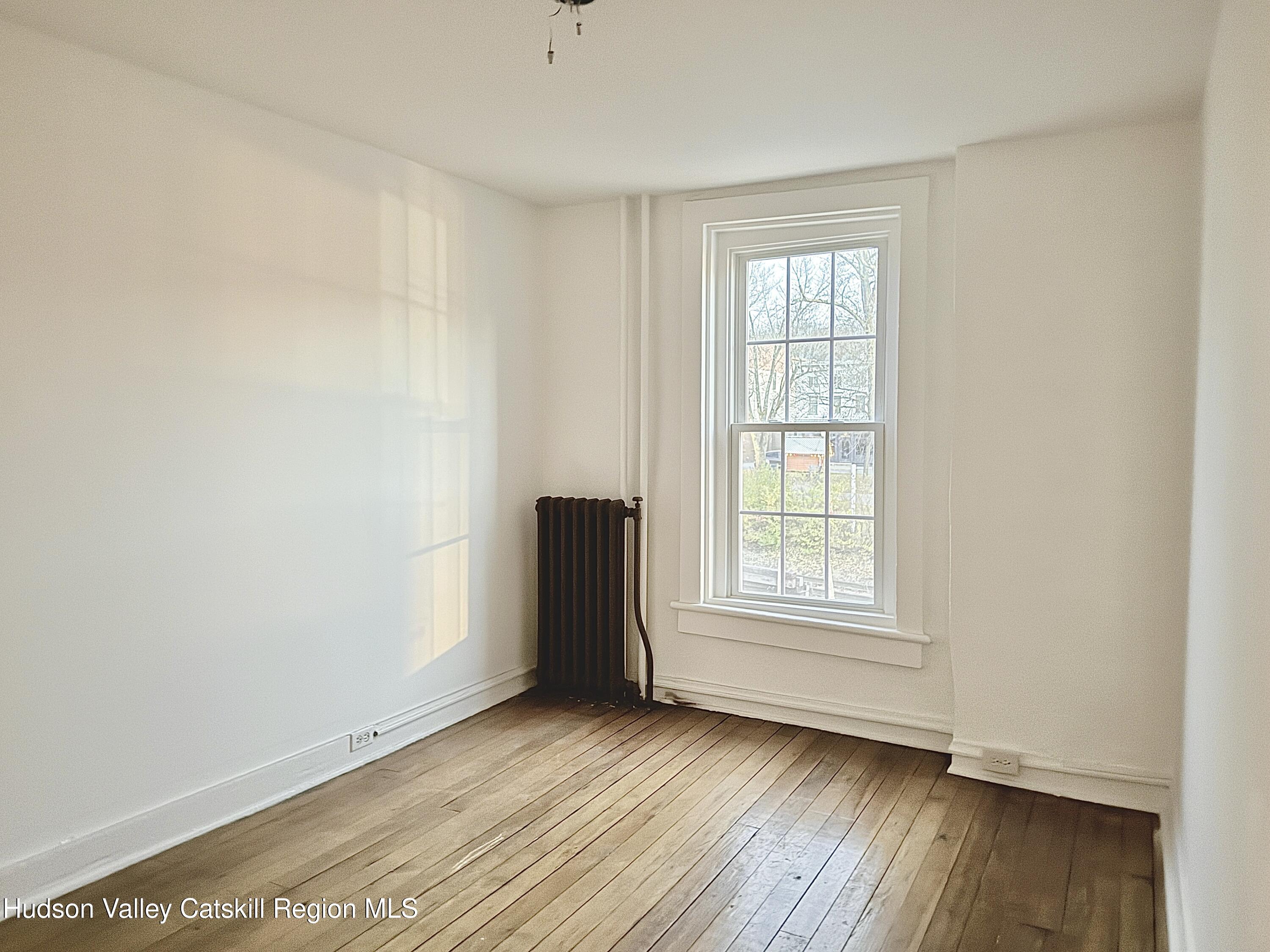624 Warren Street, Unit 2 Hudson, NY 12534 - Photo 7 of 8 an empty room with wooden floor and window