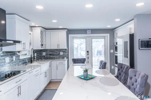 a kitchen with kitchen island a sink and white appliances