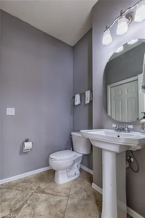a bathroom with a sink toilet and mirror