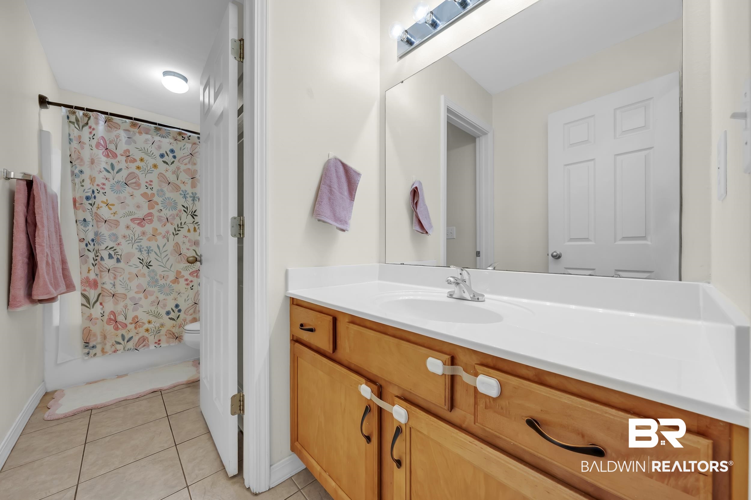 31527 Heidelbrook Loop Daphne, AL 36527 - Photo 18 of 22 Bathroom with vanity, light tile patterned flooring, and shower / tub combo with curtain
