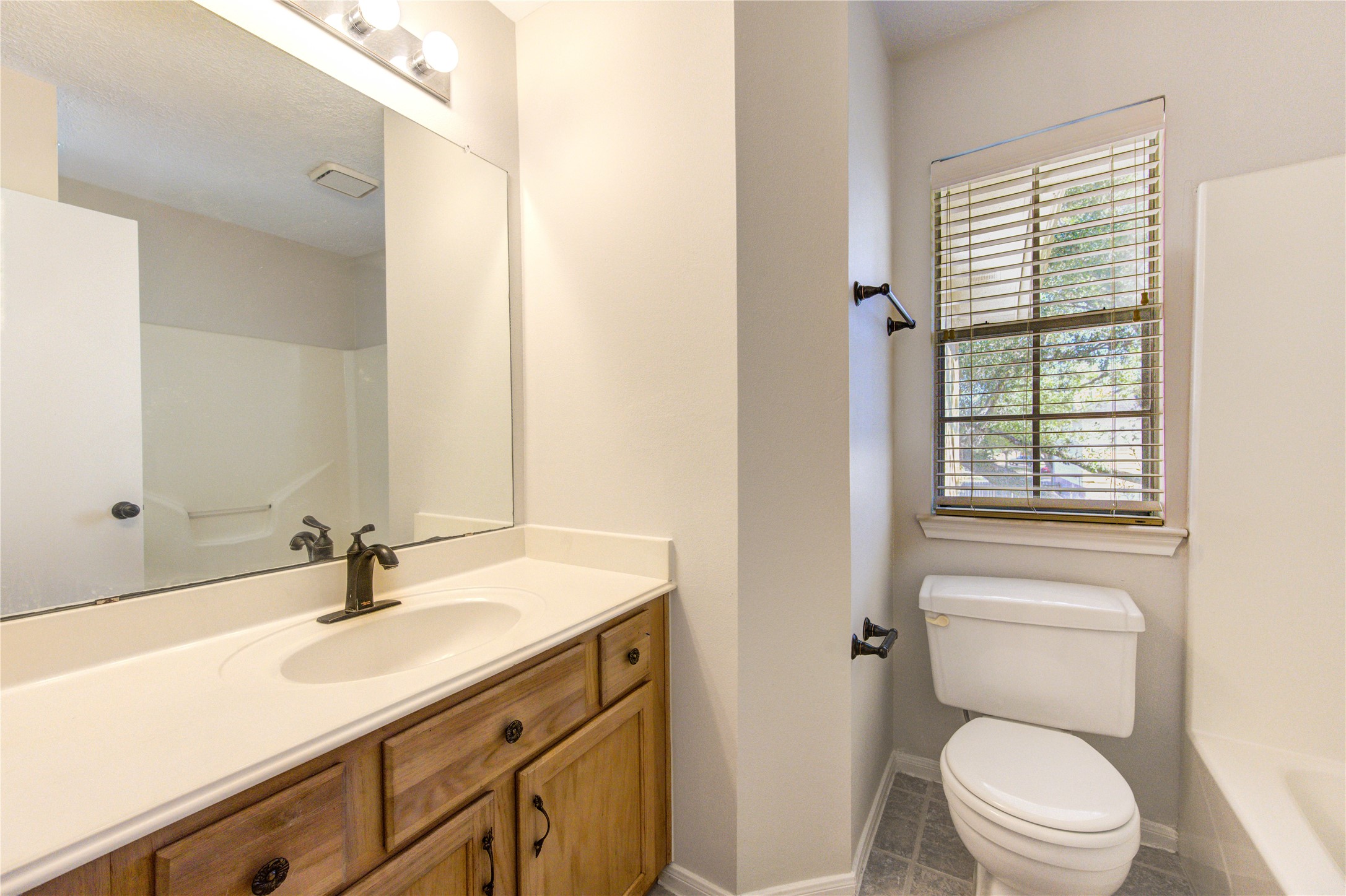 2518 Calvary Lane Katy, TX 77449 - Photo 15 of 26 a bathroom with a sink a toilet a mirror and a window