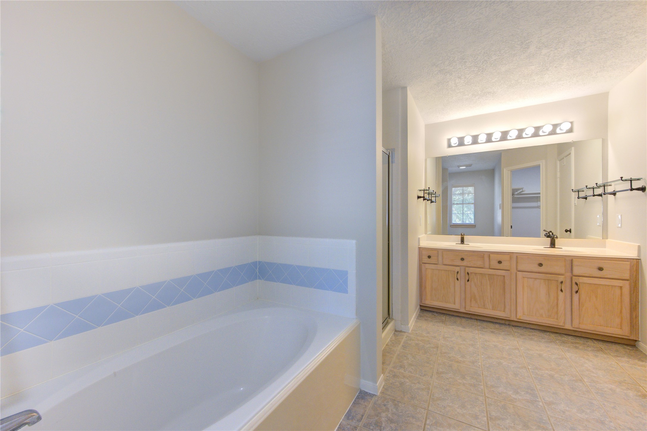 2518 Calvary Lane Katy, TX 77449 - Photo 22 of 26 a spacious bathroom with a granite countertop tub sink and mirror