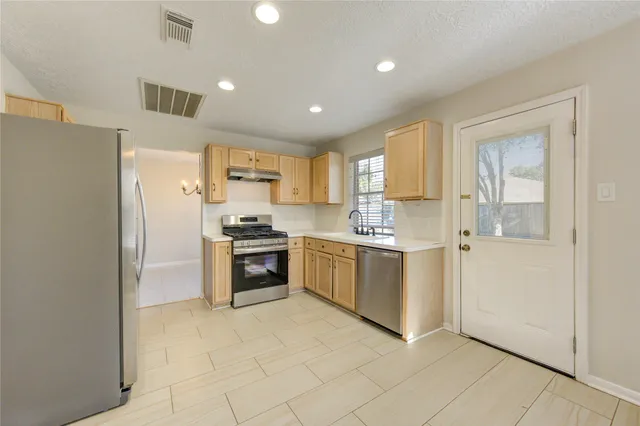 a kitchen with a refrigerator and a stove top oven