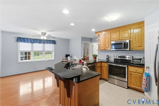 a kitchen with kitchen island a sink stove and microwave