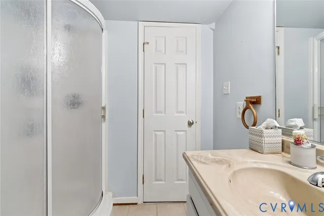 a en suite bathroom with a granite countertop sink and a mirror