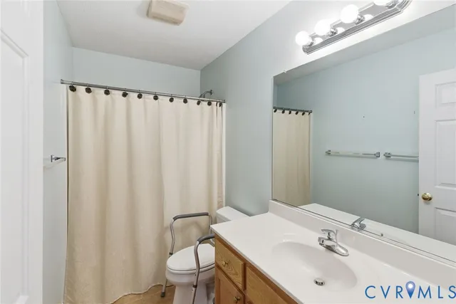 a bathroom with a sink a toilet and shower curtain