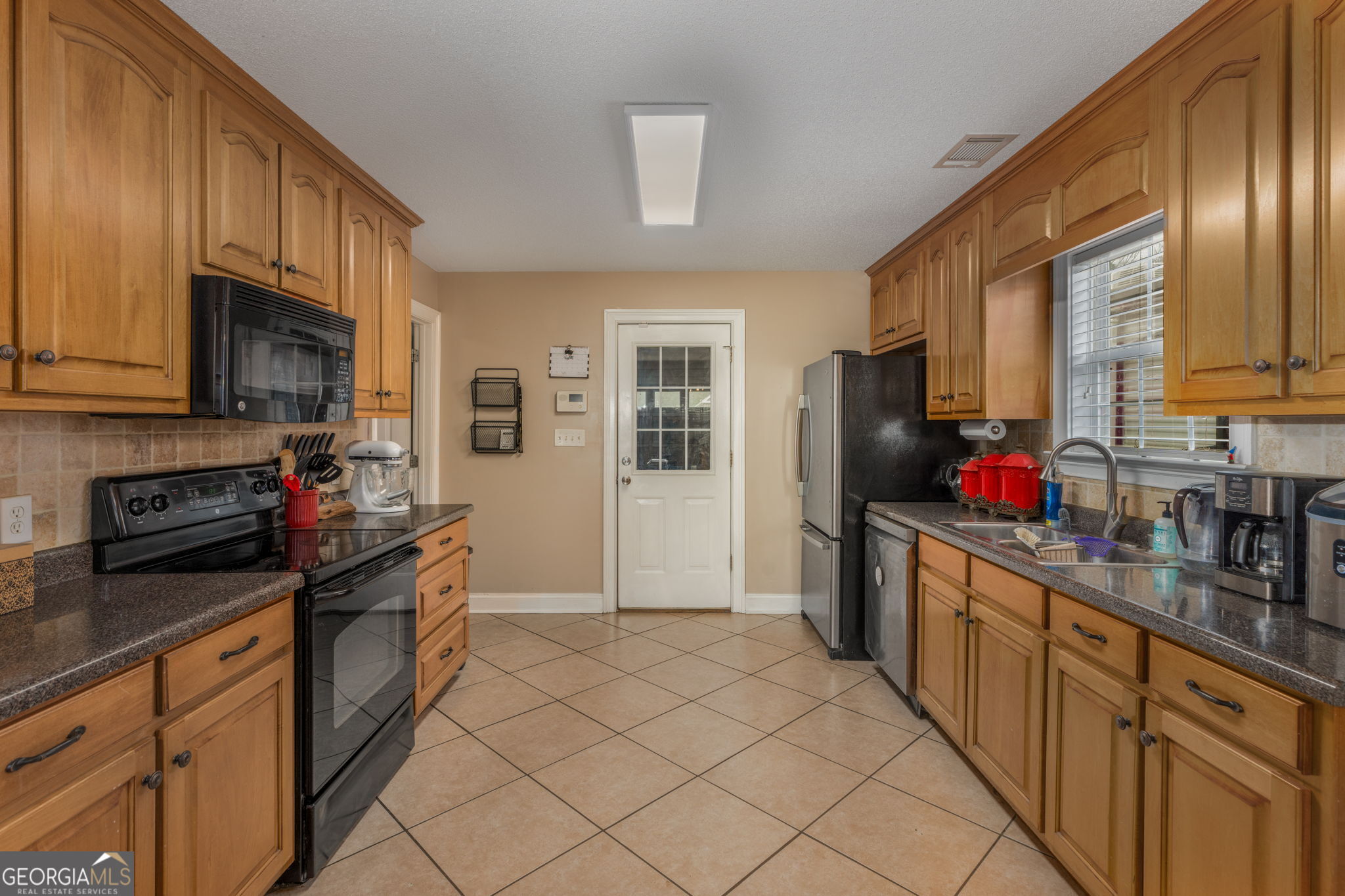 105 Galloway Street Kathleen, GA 31047 - Photo 9 of 35 a kitchen with stainless steel appliances granite countertop a refrigerator a stove top oven a sink dishwasher and wooden cabinets