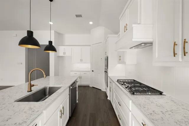 a kitchen with stainless steel appliances a sink a stove and a refrigerator
