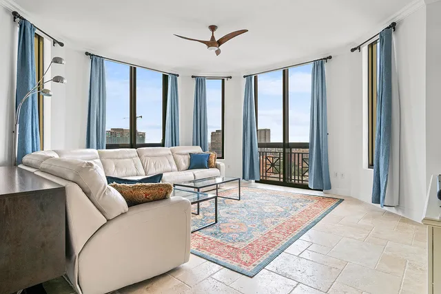 a living room with furniture and large windows