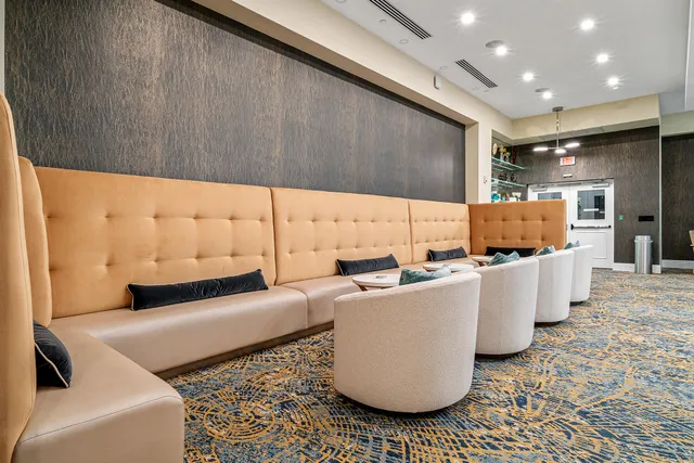 a living room with couches and kitchen view with wooden floor