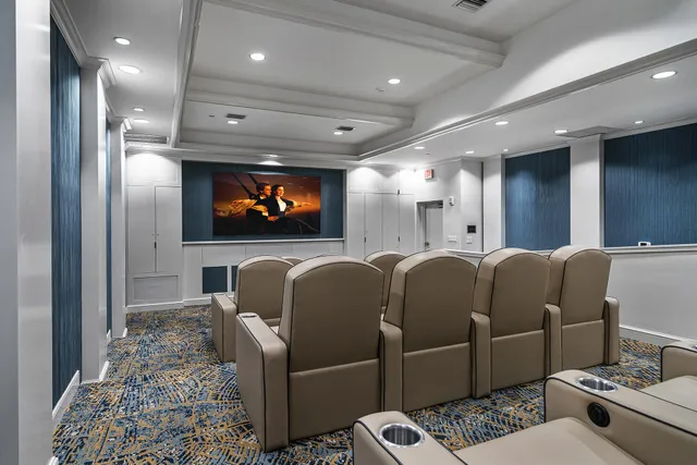 a media room with lots of chairs and a projector screen