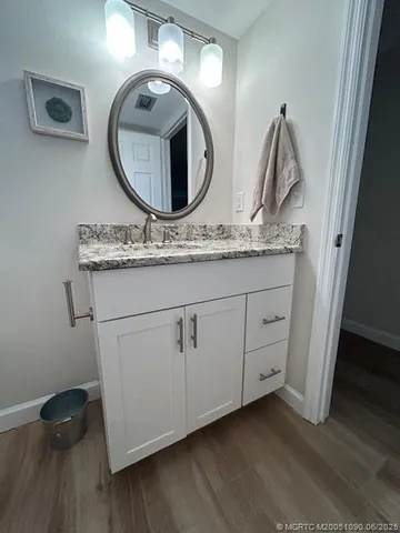 a bathroom with a granite countertop sink and a mirror