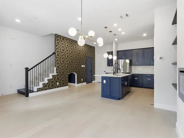 a large kitchen with a large island in the center and living room