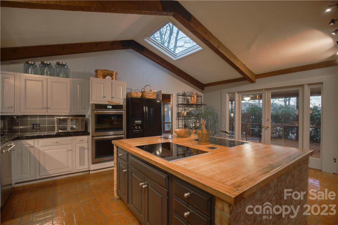 205 Hooper Creek Road Tryon, NC 28782 - Photo 17 of 45 a kitchen with stainless steel appliances granite countertop a sink and a refrigerator