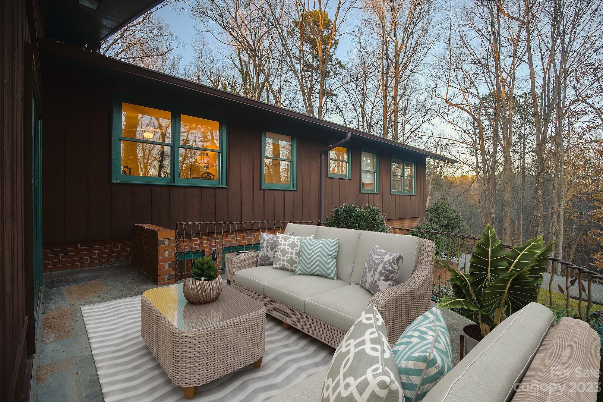 205 Hooper Creek Road Tryon, NC 28782 - Photo 26 of 45 a view of a patio with couches and a potted plant on a table