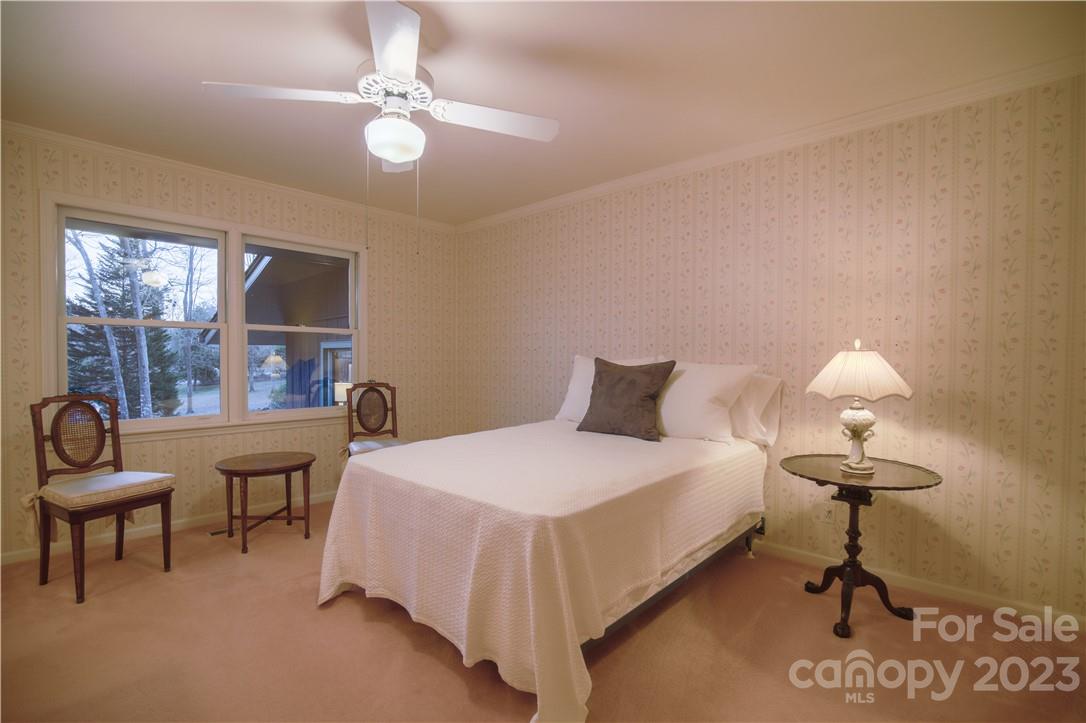 205 Hooper Creek Road Tryon, NC 28782 - Photo 36 of 45 a bedroom with a bed and a chandelier