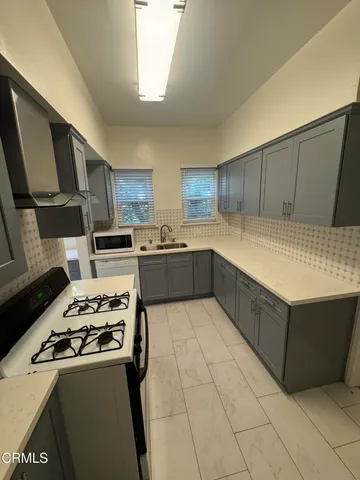 a kitchen with stainless steel appliances a stove a sink and a refrigerator