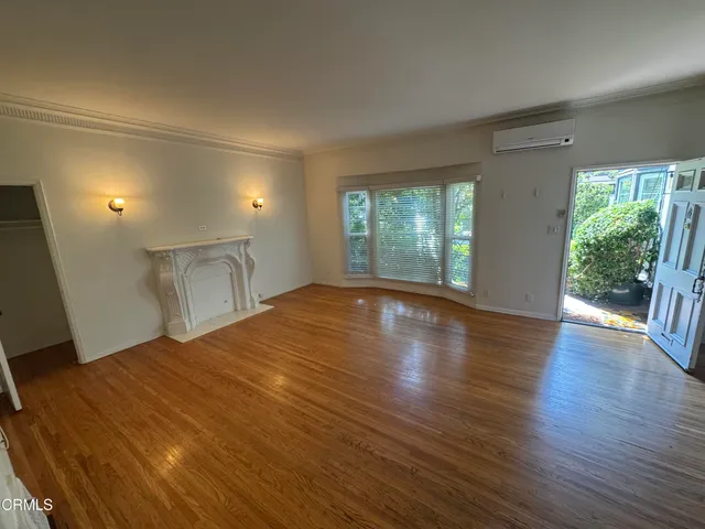 a big room with wooden floor and natural light