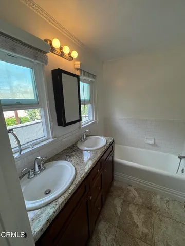 a bathroom with a granite countertop sink and a mirror