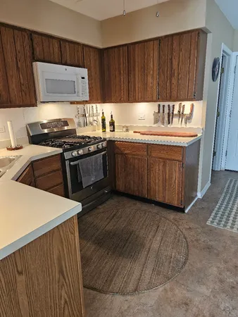 a kitchen with granite countertop a sink stove and cabinets