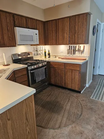 a kitchen with granite countertop a sink stove and cabinets