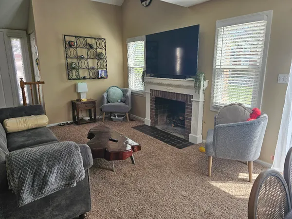 a living room with furniture a flat screen tv and a fireplace