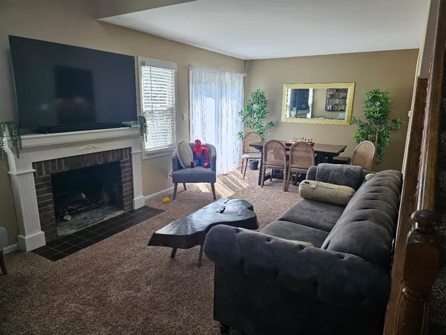 a living room with furniture a flat screen tv and a fireplace