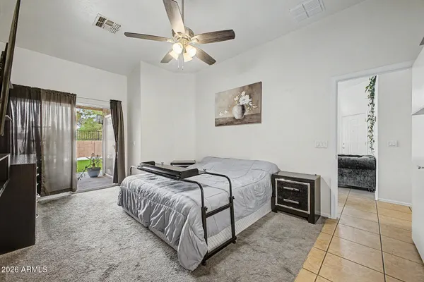 a bedroom with a bed painting on wall and a large window