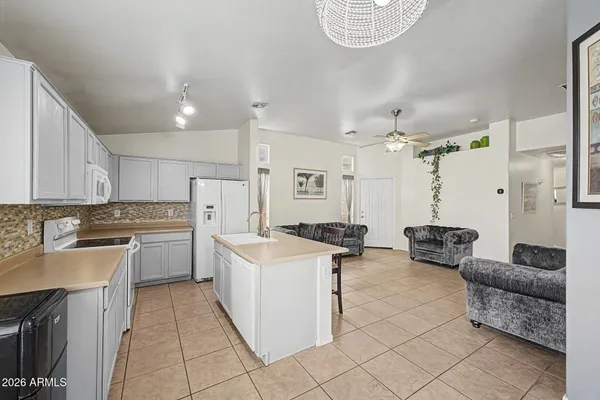 a kitchen with a stove a refrigerator and white cabinets