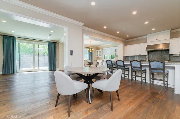 a view of a a dining room with furniture window and wooden floor