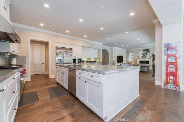 a kitchen with stainless steel appliances kitchen island granite countertop a stove and a refrigerator