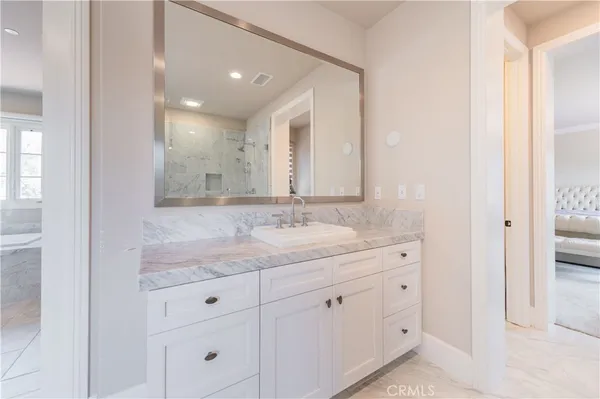 a bathroom with a granite countertop sink and a mirror