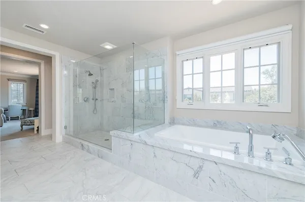 a spacious bathroom with a tub shower and windows