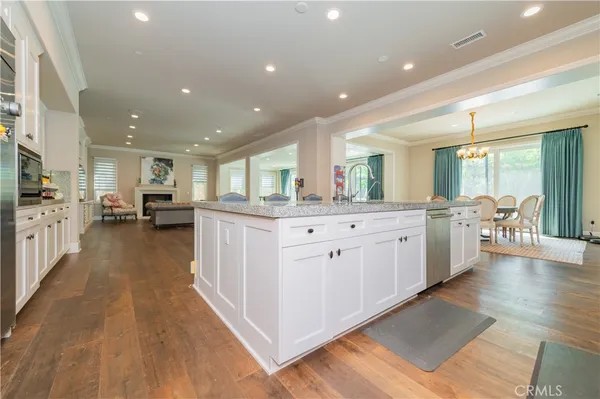 a large kitchen with stainless steel appliances lots of counter space and wooden floors