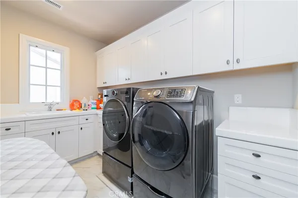 a utility room with sink dryer and washer