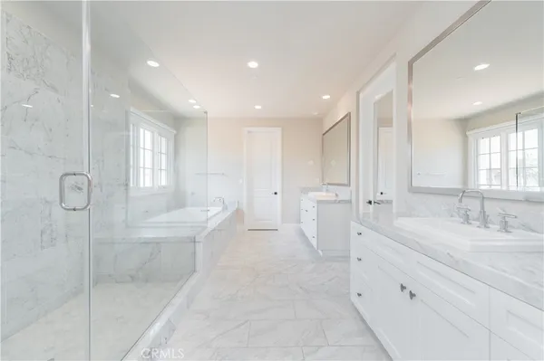 a large bathroom with a tub sink and mirror