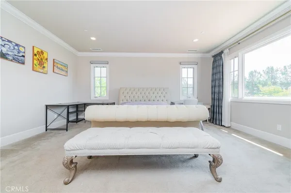 a large bedroom with a bed and window
