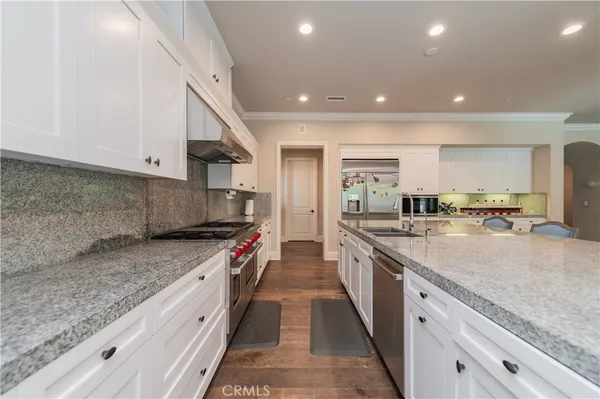 a large kitchen with stainless steel appliances granite countertop a stove and a sink