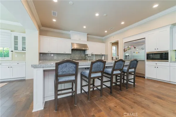 a large kitchen with stainless steel appliances granite countertop a stove a sink a dining table and chairs