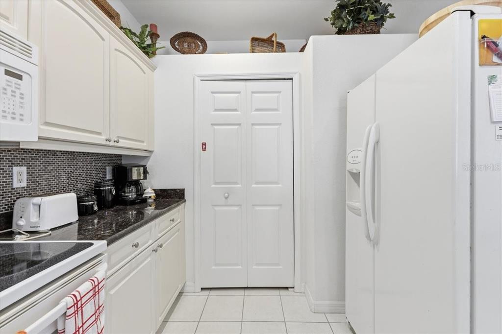 102 Natures Way, Unit 2101 Rotonda West, FL 33947 - Photo 15 of 49 a kitchen with white cabinets and stainless steel appliances