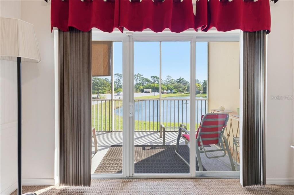 102 Natures Way, Unit 2101 Rotonda West, FL 33947 - Photo 23 of 49 a view of a bedroom with a bed and glass door