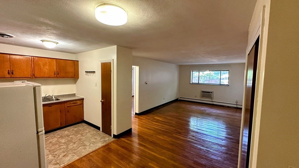 8 Riverside Street, Unit 13 Watertown, MA 02472 - Photo 11 of 18 a view of a kitchen with wooden floor and electronic appliances