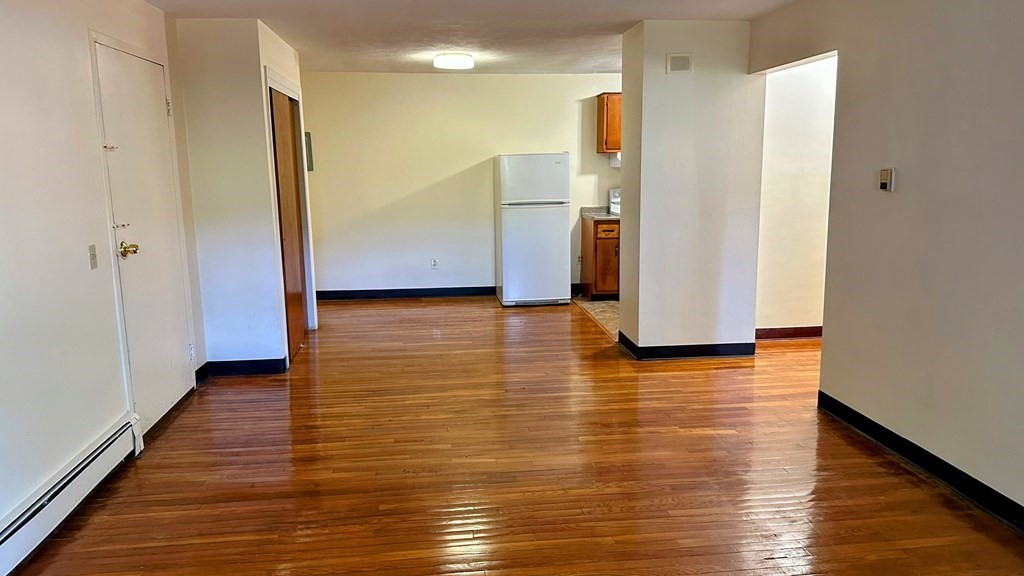 8 Riverside Street, Unit 13 Watertown, MA 02472 - Photo 13 of 18 a view of a kitchen with refrigerator and wooden floor