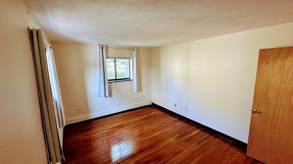8 Riverside Street, Unit 13 Watertown, MA 02472 - Photo 15 of 18 an empty room with wooden floor and windows